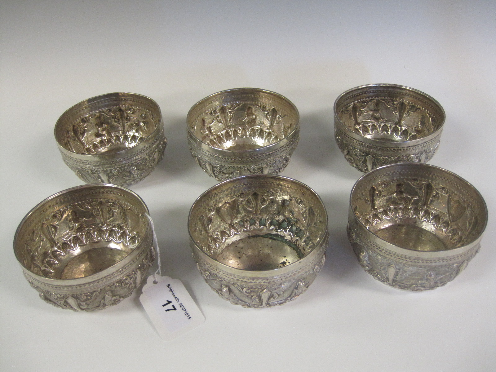 Six Eastern silver circular Bowls embossed frieze of figures and initial M within shield shape