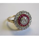 A Diamond and Ruby target Ring millegrain-set old-cut diamond within frame of tapered ruby baguettes