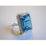 A Blue topaz and Diamond Cocktail Ring corner claw-set step-cut topaz, 9cts, within frame of