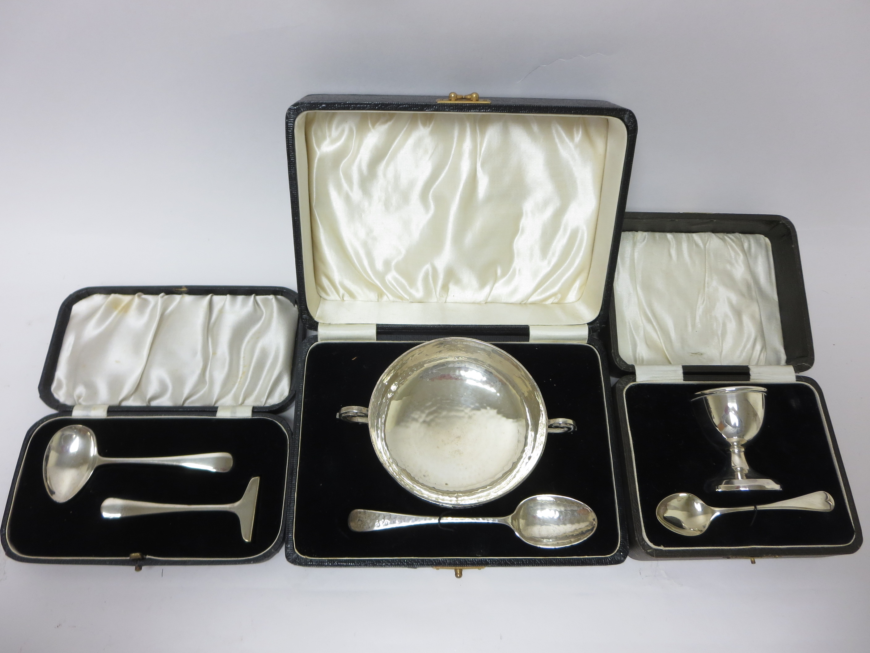 A George V silver two handled Christening Bowl and Spoon with hammered design, Birmingham 1932, a