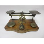 A large Set of Postal Scales with brass weights, on oak base, 12in