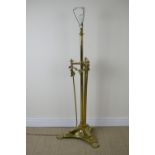 A brass Standard Lamp with turned central column and triple supports terminating in large paw feet