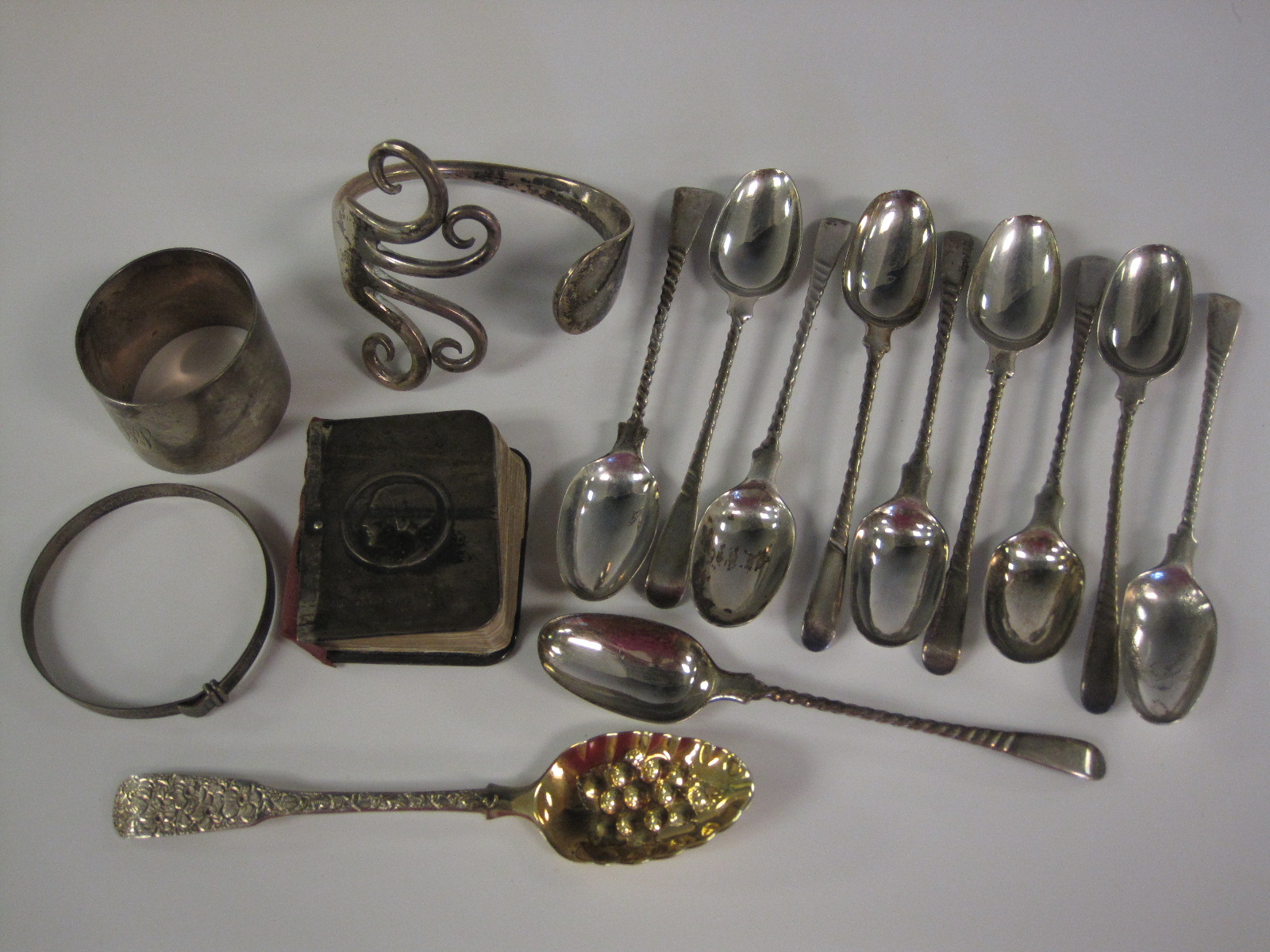 Ten white metal Teaspoons with spiral stems, engraved initials M.B., a small Georgian Berry Spoon,