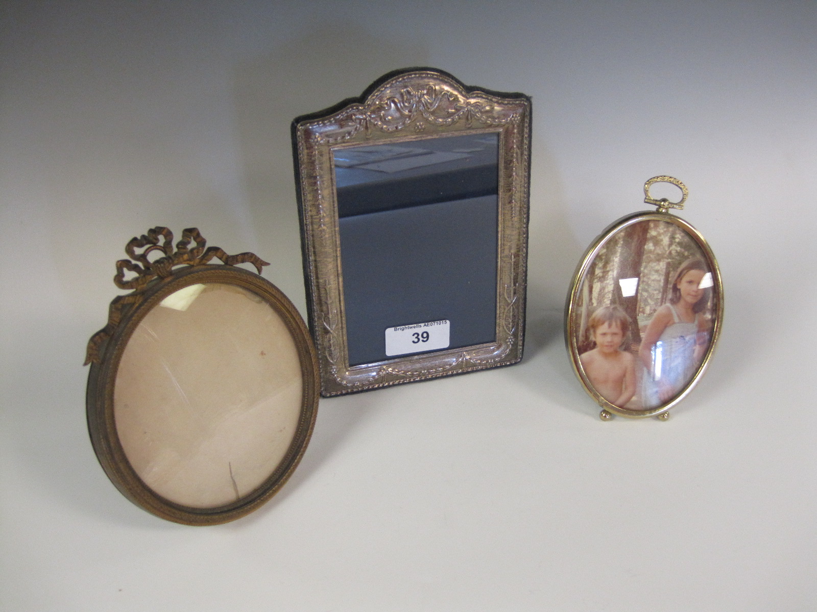 A silver Photograph Frame, two gilt metal Frames with ribbon surmounts, and six other Frames