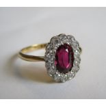 A Ruby and Diamond Cluster Ring millegrain-set oval-cut ruby, 1.37cts, within a frame of brilliant-