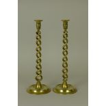 A pair of late 19th Century brass twist Candlesticks with circular bases, 16in H