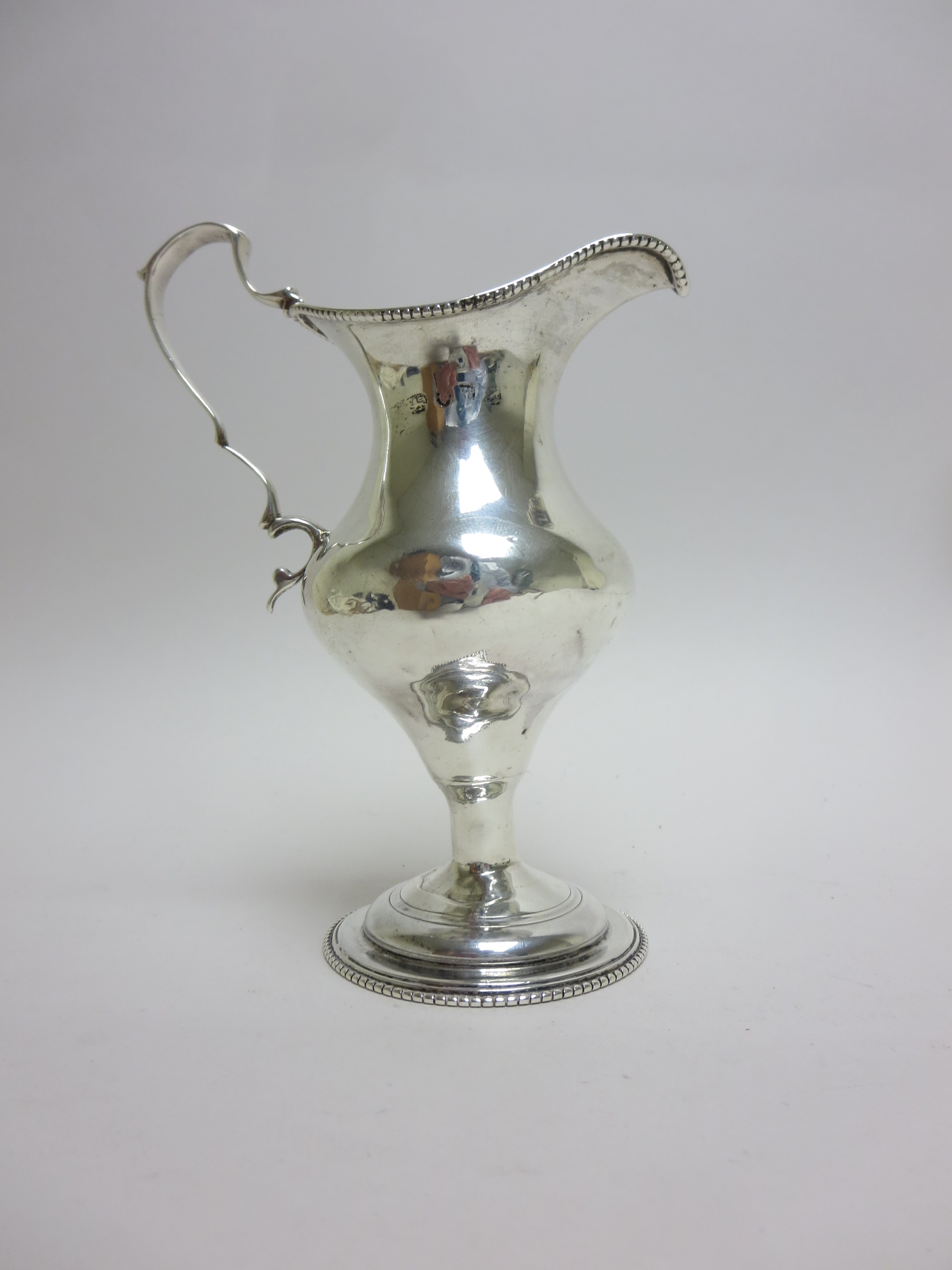 A George III silver pedestal Cream Jug with beaded rim, scroll handle, London 1774