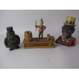 Three cast metal Money Boxes, one in form of a pipe smoking Gerald Kruger, a Trick Dog and