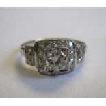 A Diamond Ring pavé-set brilliant-cut stone within square frame millegrain-set eight-cut stones with