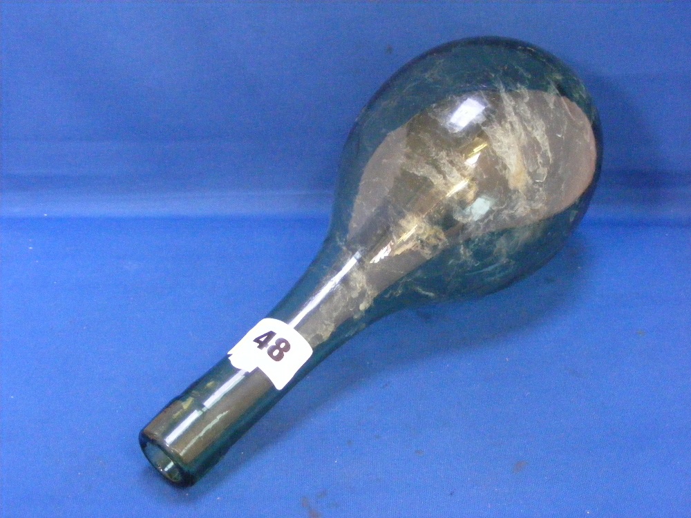 A Victorian green glass torpedo bottle.