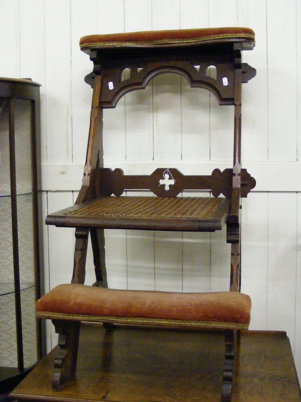 An antique folding prayer chair in a Got