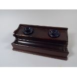 A Late Victorian Mahogany Pen Rest with Two Ink Wells.