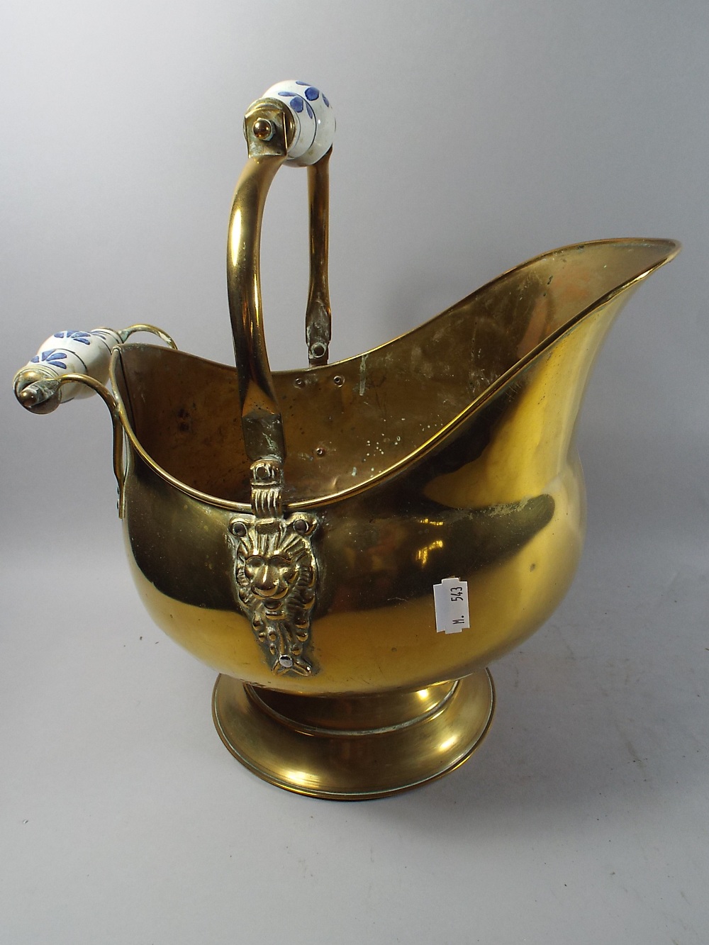 A Ceramic Handled Brass Helmet Shaped Coal Scuttle.