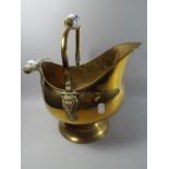 A Ceramic Handled Brass Helmet Shaped Coal Scuttle.