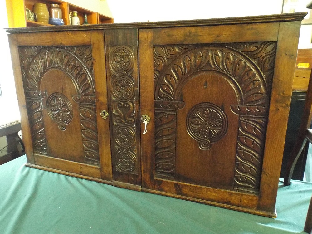 An Oak Wall Hanging Side Cabinet with Carved Doors.