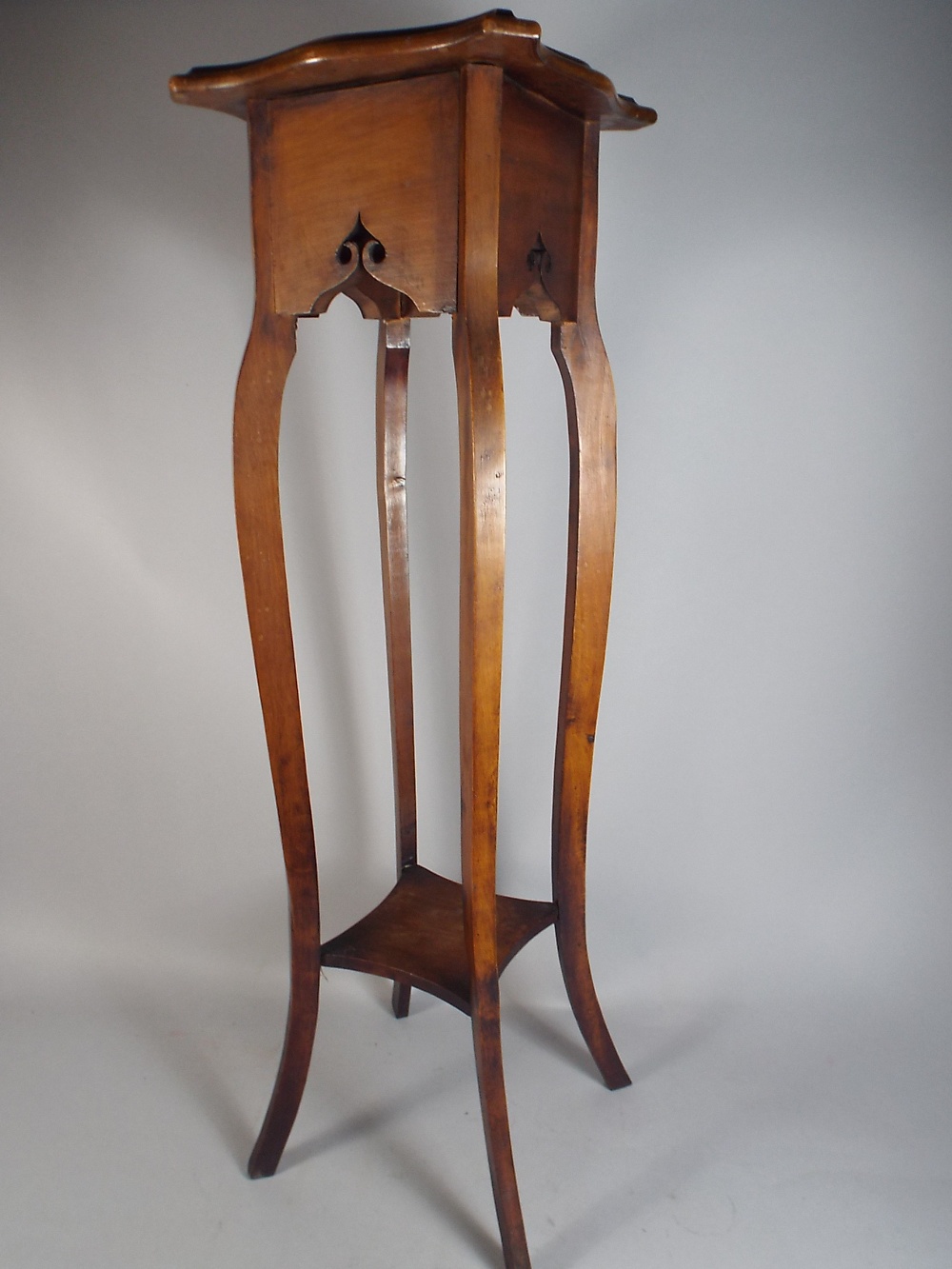 A Walnut Jardiniere Stand with Stretcher Shelf.