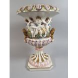 A Large Capodimonte Urn Decorated with Figures in Relief. Gilt Handles and Floriate Borders.