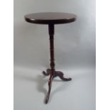 A George III Mahogany Kettle Stand with a Solid Top over Turned Stem and Tripod Base.