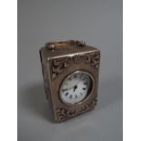 A Silver Cased Carriage Clock, Decorated with Embossed Cherubs and Stylised Wreaths.