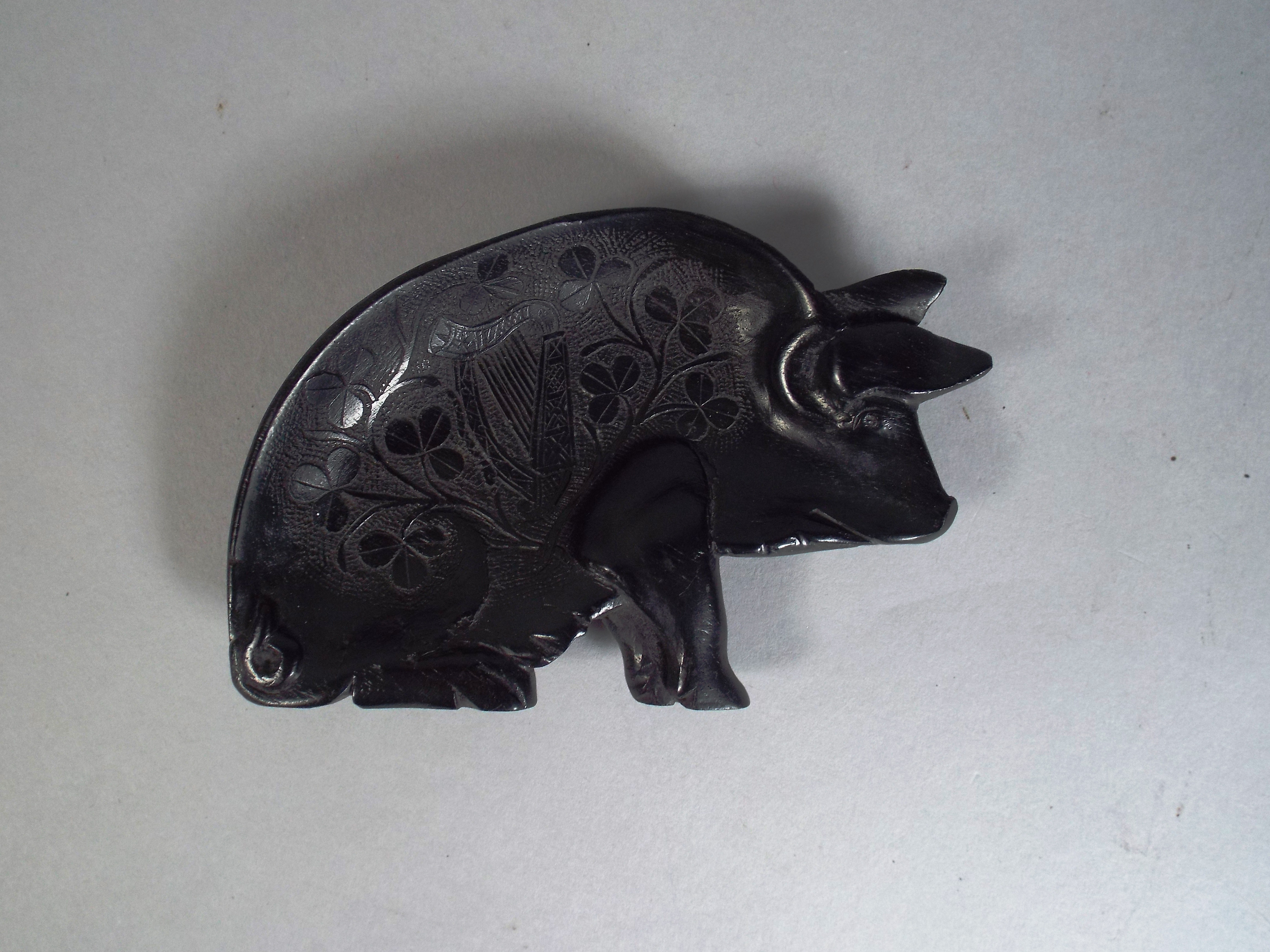 A 19th Century Irish Bog Oak Pin Tray in the Shape of a Pig. Carved with Shamrock and Harp Detail.