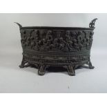 A 19th Century Metal Wine Cooler with Embossed Cherub and Vine Decoration on Scrolled Feet,