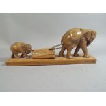A Carved Wooden Study of Elephants Pulling Log.