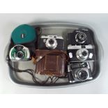 A Collection of 35 mm Cameras and A Canon Digital Camera.