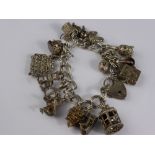 A Solid Silver Charm Bracelet, seventeen charms and hallmark heart shaped clasp.