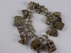 A Solid Silver Charm Bracelet, seventeen charms and hallmark heart shaped clasp.