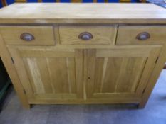 A Contemporary Oak Side Board, with three drawers and two cupboards below with panelled doors, est