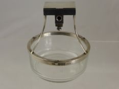 A silver 1897 Vesta and attached cigar cutter fitted onto a glass cigar ashtray.