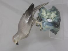 A Porcelain Figure of a Bird of Prey, seated on a rock, marks to base, approx 36 cms.