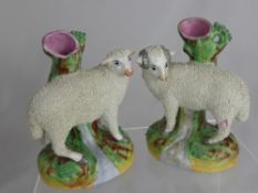A Pair of Staffordshire Spill Vases, depicting a standing ram and sheep beside a stream, est