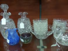 A collection of cut glass items comprising two decanters (one stopper missing), a matching water jug