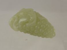 A Chinese Celadon Jade carving of a mouse on a bunch of grapes.