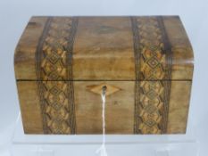 A vintage wooden sewing box, decorated with inlaid banding and central cartouche, containing some