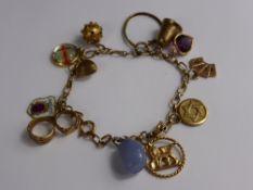 A 9 ct gold hallmarked charm bracelet having miscellaneous gold charms including one being 14 ct,