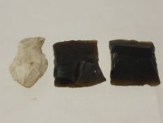 Two Stone Age cutting and skinning flints together with an arrow head.