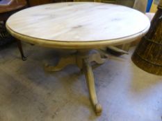 A round pine kitchen table supported on a bulbous column and three feet decorated with swirls and