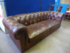 A brown leather Chesterfield button back sofa being a three seater.