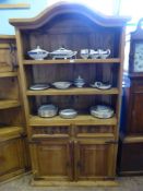 A Mexican pine dresser having an arched top, open shelves with drawers below and cupboards below,