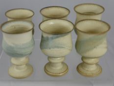 A Set of Eight Studio Pottery Chalices, cream and light green glaze.