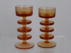 Two Wedgwood amber glass candle holders having three tiers, est. heights 15 and 16 cms. (2)