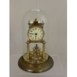 A Brass Anniversary Clock, with cream enamel face stamped DRGM No 403658 under a glass dome.