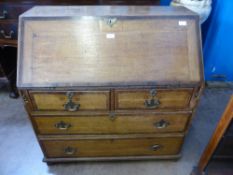 An Antique Oak Writing Bureau the desk having two small drawers and two large drawers beneath, the