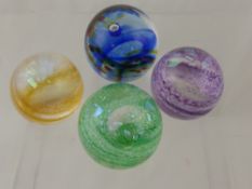 Three Caithness Paperweights of the Shimmer series, including green, purple, orange and Rainbox