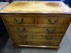 A small reproduction yew wood style chest of drawers having two short and three long drawers,