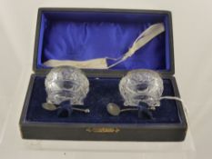 A silver rimmed cut glass cruet set, Birmingham hallmark, mm. G E W together with a matching spoon.