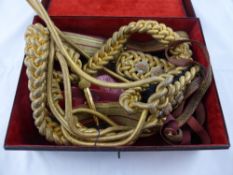 Royal Horseguards Aiguillette and Belt.. A velvet lined metal case with oval brass label Rogers &