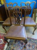 Five Chippendale style dining chairs and one carver, on ball and claw feet, with leather seats.